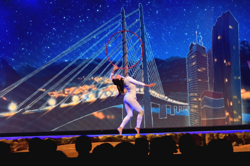 Gymnastin mit Reifen vor Video Leinwand