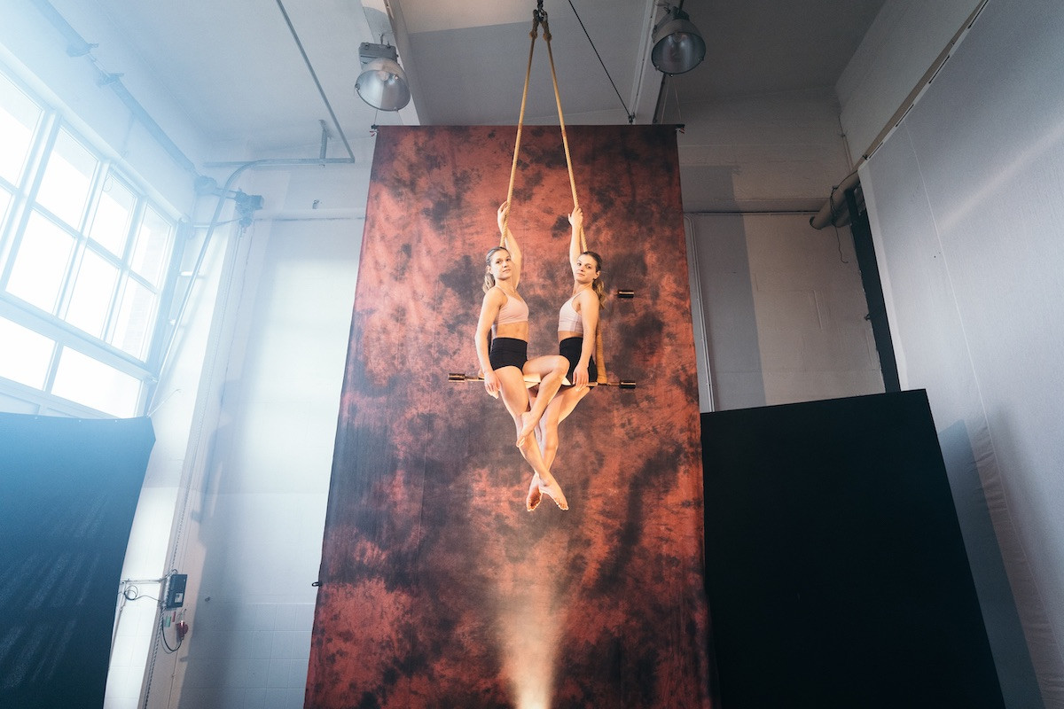 Luftartistik Zwillinge am Trapez vor Leinwand